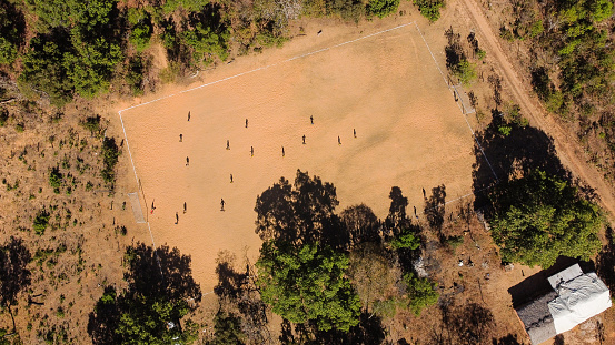 Brazilian boys playing lowland soccer on a dirt football field in the countryside of Brazil