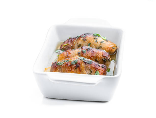 istock Chicken breasts wrapped in bacon in white dish isolated on white 1423170480