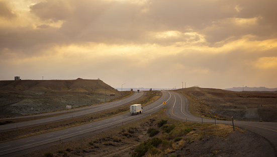 Semi-truck driving in Utah at sunset