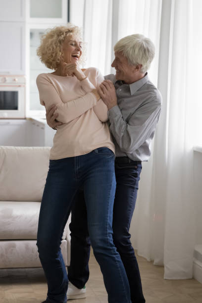istock Cheerful excited middle aged retired couple celebrating anniversary 1423172399