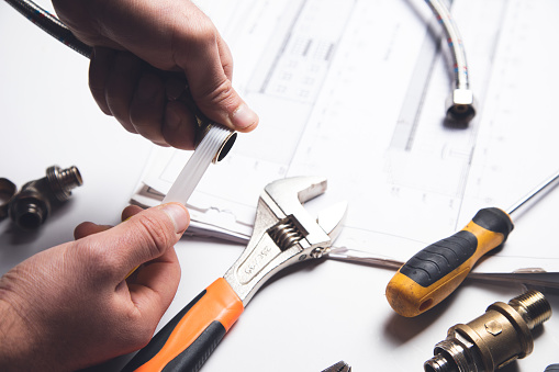 Plumber putting seal tape on a thread of a plumbing fitting