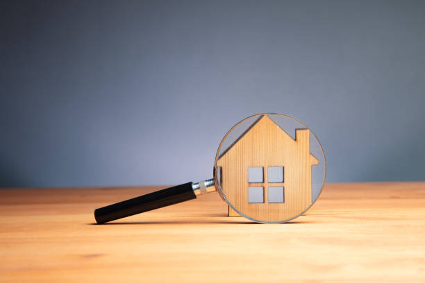istock magnifier glass with house model, house selection 1423172697