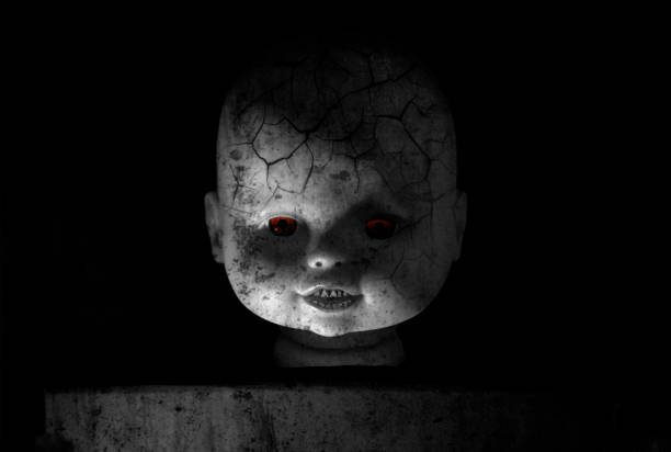 Zombie doll portrait. Creepy of doll face with glowing red eyes and zombie skin in the black background. Zombie doll portrait. Halloween concept. creepy doll stock pictures, royalty-free photos & images