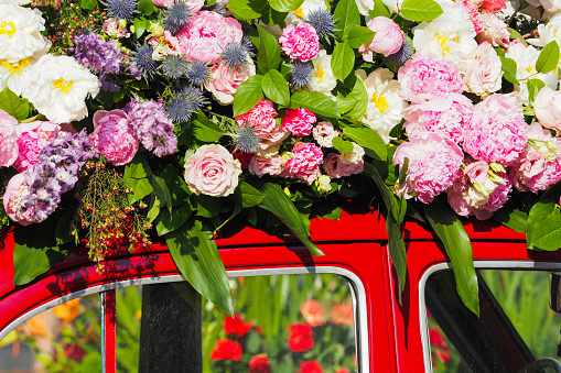 Festival of flowers, beautiful flower arrangement on the roof of a vintage red car