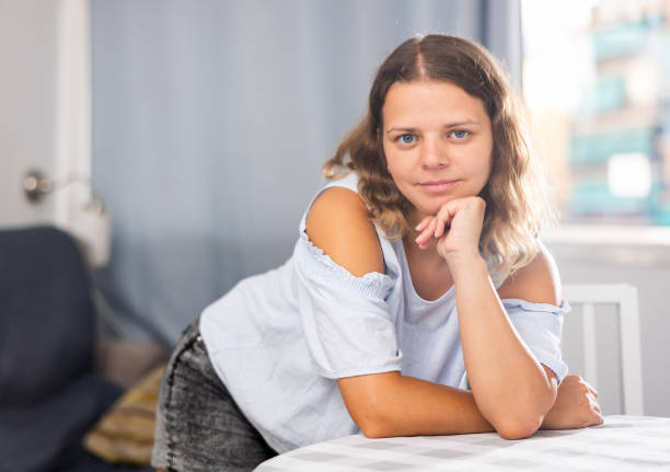 istock Smiling girl at home interior, posing on camera 1423175939