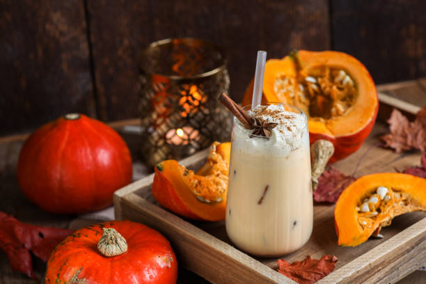 pumpkin spice latte milkshake drink with whipped cream and cinnamon spice in rustic wood kitchen - latté pumpkin spice coffee imagens e fotografias de stock
