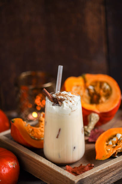 pumpkin spice latte milkshake drink with whipped cream and cinnamon spice in rustic wood kitchen - latté pumpkin spice coffee imagens e fotografias de stock