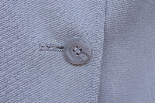 part of clothing made of fabric and one big gray plastic button