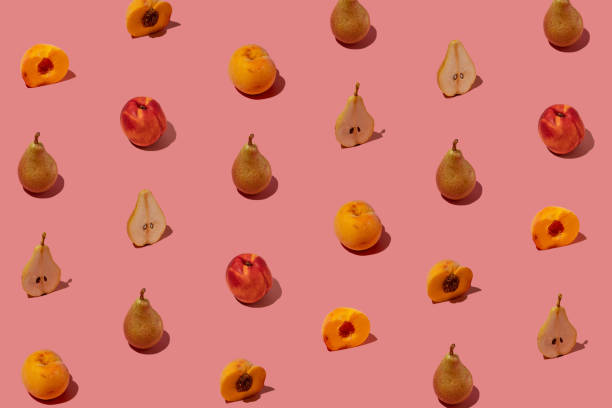 istock Creative pattern made with fresh pears and peaches on pastel pink background. Minimal summer fruit arrangement. 1423179951