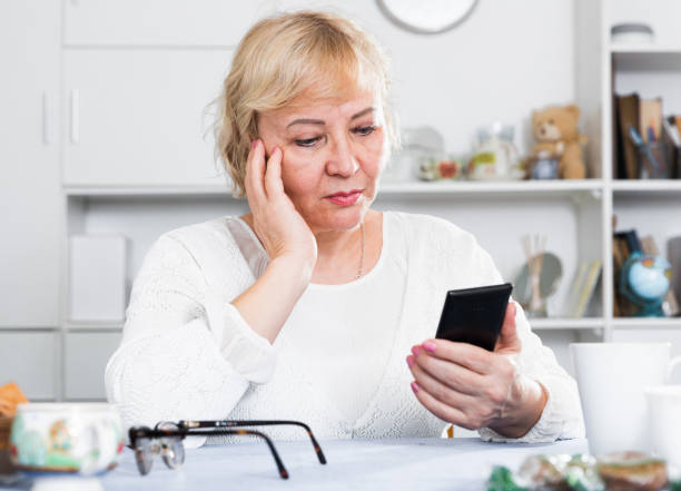 istock Mature woman with smartphone 1423180413