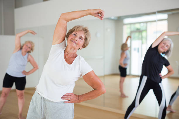 Portrait of mature energetic woman practicing active dancing at a group lesson stock photo