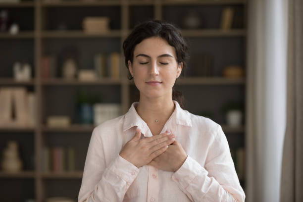 istock Woman put folded palms on chest feels grateful 1423181291