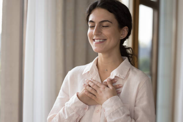 istock Young woman put folded palms on chest looks grateful 1423181293
