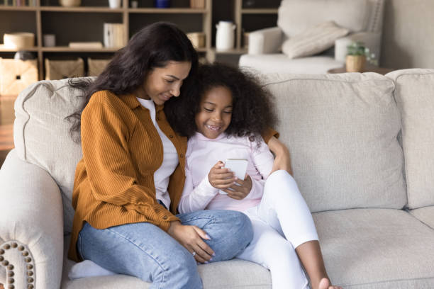 istock African girl her mother have fun using smartphone 1423181358