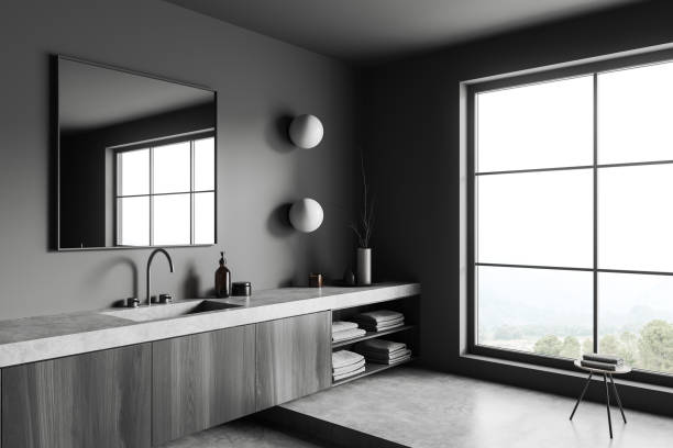 istock Grey bathroom interior with sink and panoramic window, accessories on dresser 1423186909