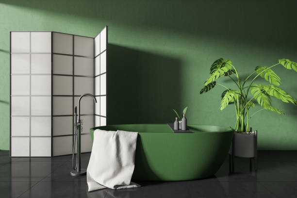 istock Front view on dark bathroom interior with bathtub, partition, plant 1423187001