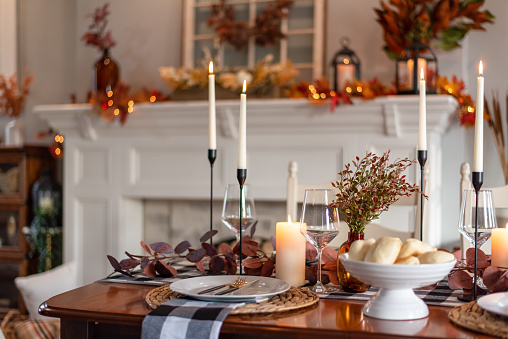 Dinner table decorated for cozy fall holiday gathering