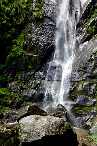 Bhutan, Paro district: waterfall on the cliff-face by the Tiger's Nest monastery / Paro Taktsang / Taktsang Palphug - part of the Tiger’s Nest trail, the long hike made by pilgrims and visitors, Taktsang heritage forest.