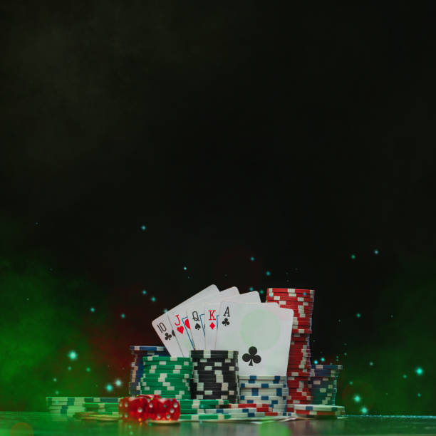 composition en studio de jetons de poker, de dés et d’une pile de cartes à jouer sur le bureau avec une texture grunge sur fond noir avec effet de fumée et de paillettes - bureau de pmu photos et images de collection