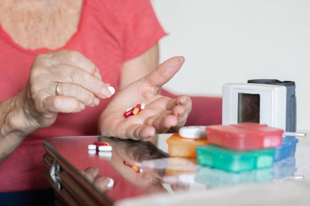 自宅で薬、治療、血圧計、酸素濃度計をチェックする高齢女性の手 - ipad senior adult 70s adult ストックフォトと画像