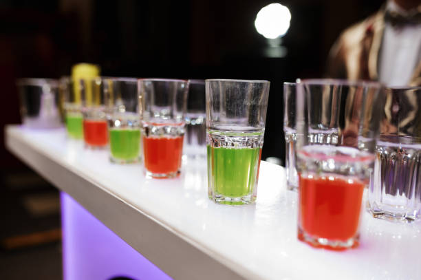 many glasses with green and red drinks stand in a row