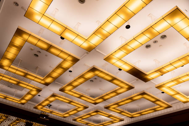 istock conceptual chandeliers, square yellow lamps on white ceiling 1423211404