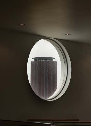 Bangkok, Thailand - 15 May 2022 : View of Modern building as seen through from round circular window glass on cement wall. Space for text, Selective Focus.