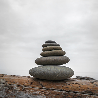 A rock cairn stands on a stony beach under moody skies, Narragansett, Rhode Island