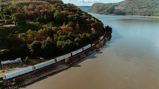 Amtrak train going along Hudson river with a few boats on the water