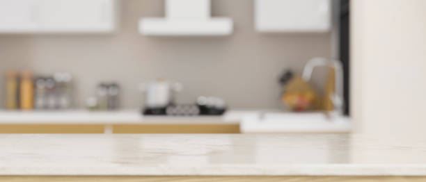 istock White marble tabletop with empty space over blurred modern home kitchen in the background 1423227616