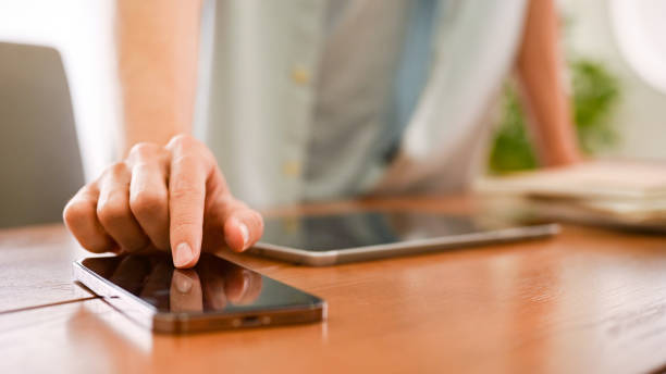 istock A young man touching on smartphone screen, using mobile phone this desk. Close-up finger 1423227674