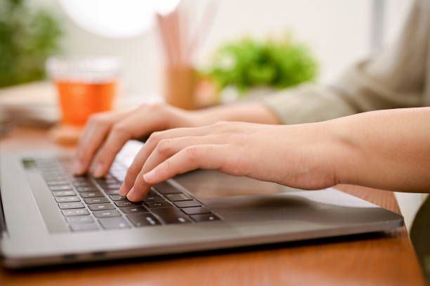 istock close-up hands image, A female's hands typing on notebook laptop keyboard, using laptop computer. 1423227675