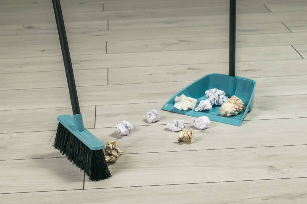 istock A brush that sweeps garbage from paper into a dustpan on a wooden floor. 1423230850
