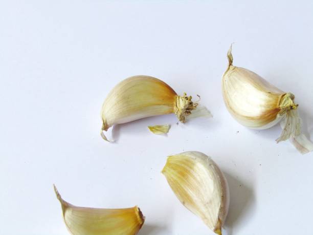 istock Four cloves of garlic on a white background 1423232172