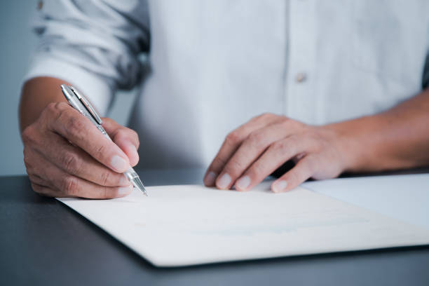 istock Young executives are signing documents for business contracts. Transaction and document management concepts include negotiating corporate entities and filling out legal forms or agreements. 1423249504