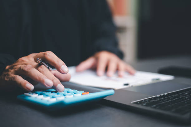 The auditor is analyzing his home documents, balance sheet management concept. form validation budget management and management of meeting reports, tax calculations