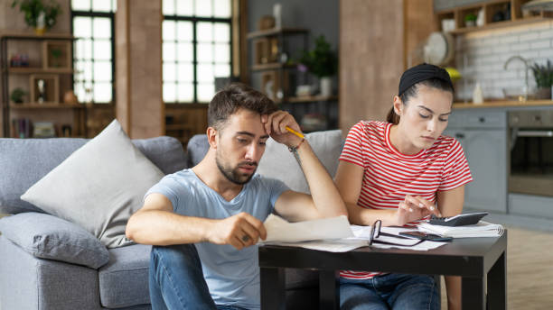 Frustrated concerned young couple calculating overspend budget, doing paperwork job at laptop, talking about financial problems, insurance, mortgage, fees, loan conditions, bankruptcy, economic inflation Frustrated concerned young couple calculating overspend budget, doing paperwork job at laptop, talking about financial problems, insurance, mortgage, fees, loan conditions, bankruptcy, economic inflation over spend stock pictures, royalty-free photos & images