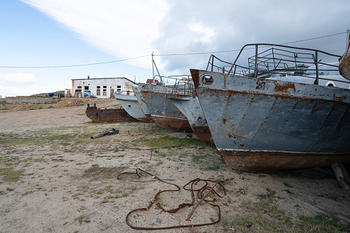 Olhon island, Baikal lake, Russia - September 16 2019: Cemetery of old ships, metal rusty fishing boats on baikal lake.  Stored on a shore of bail lake.