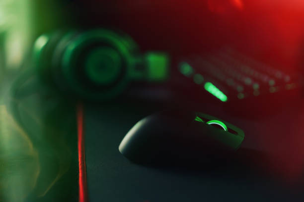 istock Computer gaming mouse and keyboard and green hedset with green backlight on black mat 1423256129