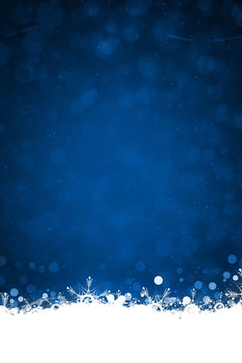 White colored snow and illuminated glowing snowflakes at the bottom edges or border of a dark blue vertical backgrounds. Can be used as Xmas , New Year day celebrations background, wallpapers, gift wrapping sheets, posters, banners and greeting cards. Small glitter like or glittery dots shining all over.
