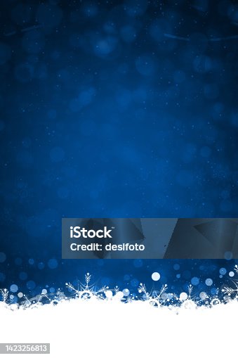 istock White colored border or frill of snow and ethereal shining Christmas snowflakes at the bottom of a vibrant dark midnight blue vertical shining festive Xmas backgrounds with bubbles like circles or dots 1423256813