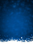 istock White colored border or frill of snow and ethereal shining Christmas snowflakes at the bottom of a vibrant dark midnight blue vertical shining festive Xmas backgrounds with bubbles like circles or dots 1423256813