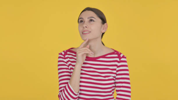 istock Pensive Spanish Woman Thinking on Yellow Background 1423261208