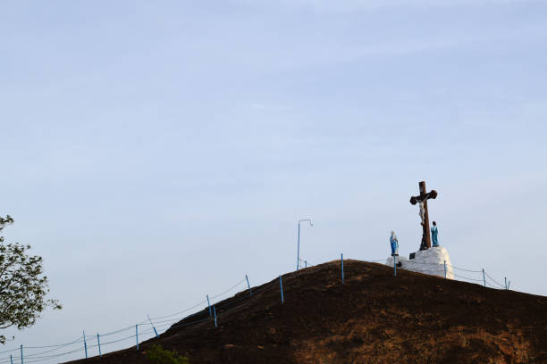 Low angle view of Cross with crucified jesus christ on top of the mountain with blue sky Low angle view of Cross with crucified jesus christ when sunset on top of the mountain with blue sky in a village of Tamilnadu, India what mountain was jesus crucified on stock pictures, royalty-free photos & images