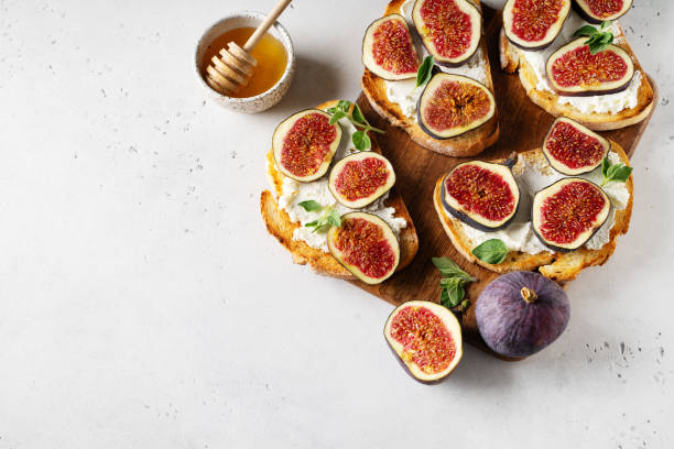 istock Fig bruschetta, bread and cream cheese and fruit on white background 1423266599