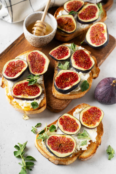 istock Fig bruschetta, bread and cream cheese and fruit on white background 1423266613