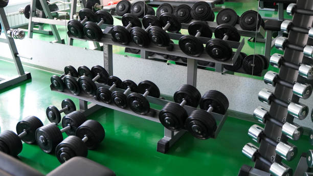 Gym with a large selection of dumbbells and barbells stock photo