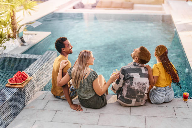 istock Young cheerful couples talking by the swimming pool. 1423271308
