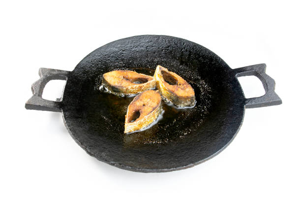 Hilsha or ilish fish frying on a cast iron pan. fish frying on a black pan. Hilsha or ilish fish frying on a cast iron pan. fish frying on a black pan. iron pan fish  stock pictures, royalty-free photos & images