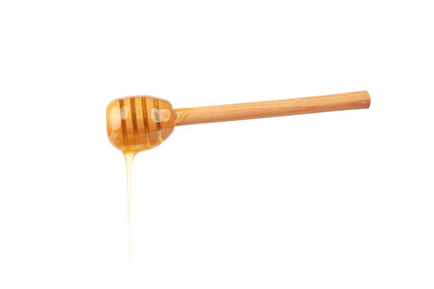 istock wooden spoon with honey on white background. 1423272847